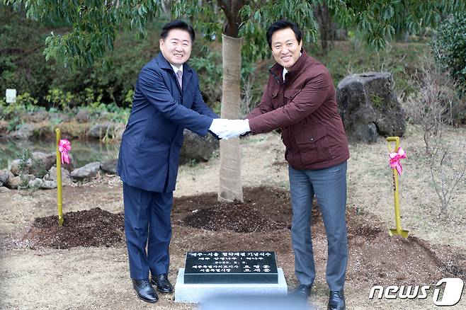 오영훈 제주특별자치도지사(왼쪽)와 오세훈 서울특별시장이 3일 오후 제주시 한라수목원 잔디광장에서 제주도·서울시 교류강화 협약 기념 식수 후 손을 맞잡고 기념촬영을 하고 있다.2023.2.3/뉴스1 ⓒ News1 오미란 기자