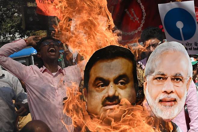 6일(현지 시각) 인도 콜카타에서 시위 참가자들이 아다니 그룹 사태에 대한 의회 조사를 촉구하며 나렌드라 모디(오른쪽) 총리와 가우탐 아다니 회장의 종이 인형을 불태우고 있다. /AFP 연합뉴스