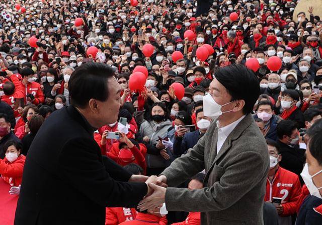 지난해 3월 당시 윤석열 국민의힘 대선 후보가 부산 연제구 온천천 일대에서 열린 '국민이 승리합니다' 부산 거점유세에서 연설을 마친 뒤 안철수 국민의당 대표와 악수하고 있다. 부산=오대근 기자