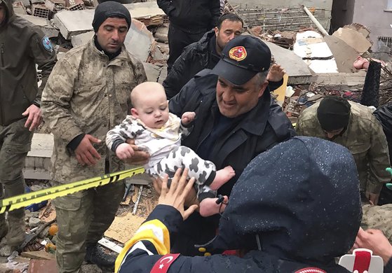 튀르키예의 한 건물 잔해 속에서 아기가 구조되고 있다. 사진 AP=연합뉴스