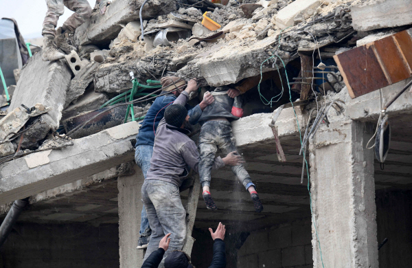 튀르키예에서 규모 7.8과 7.5의 강진이 잇따라 발생한 6일(현지시간) 인접한 시리아 알레포주 아프린시 잔다리스의 붕괴한 건물 잔해에서 시민들이 다친 여자아이를 구조하고 있다. 아프린시는 시리아 반군이 장악한 곳이다. 시리아와 국경을 맞댄 지역에서 일어난 이번 강진으로 지금까지 두 나라에서 약 3천500명이 숨졌다. (잔다리스[시리아] AFP=연합뉴스)