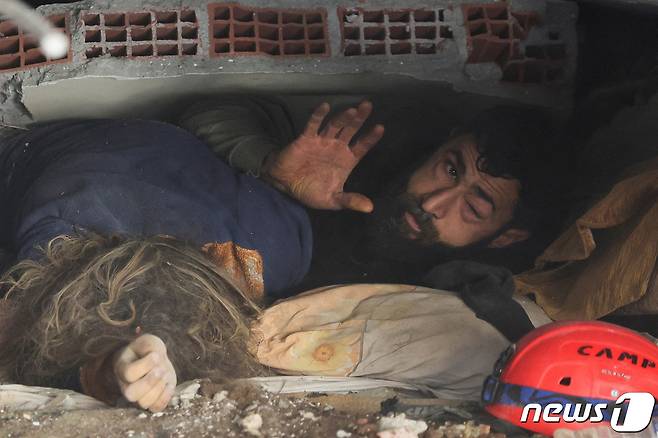8일(현지시간) 튀르키예 하타이에서 한 남성이 대지진으로 무너진 건물 잔해에 깔린 채 손을 흔들고 있다. 2023.2.8 ⓒ 로이터=뉴스1 ⓒ News1 정윤미 기자
