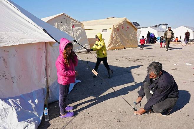 8일 시리아 북서부 알레포주 진다리스에서 지진으로 집을 잃은 한 시리아인이 임시 텐트를 치고 있다. AFP 연합뉴스