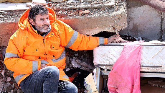 규모 7.8의 강진이 덮친 튀르키예 남부 카라만마라슈에서 건물 잔해에 깔려 숨진 15세 딸의 손을 살아남은 아버지가 놓지 못하고 있다. [AFP=연합뉴스]