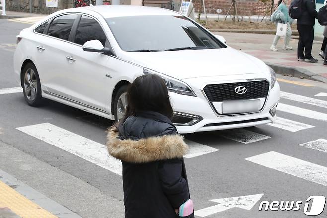 9일 오후 제주시 이도초등학교 어린이보호구역 내 횡단보도에서 한 승용차가 일시정지 없이 지나가고 있다. 개정 도로교통법에 따라 어린이 보호구역 내 신호기가 없는 횡단보도에서는 보행자 유무와 관계없이 일시정지해야 한다. 2023.2.9/뉴스1 ⓒ News1 오현지 기자