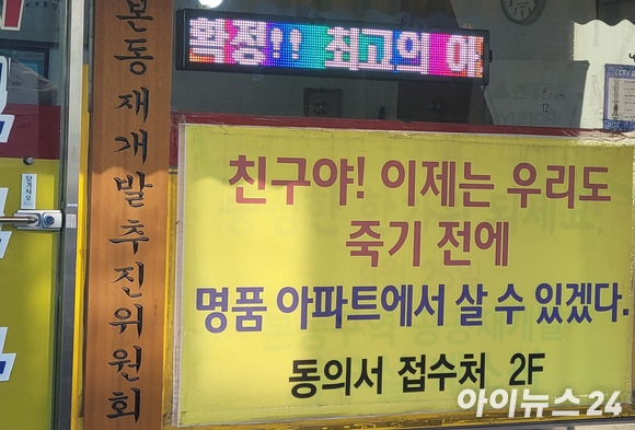 본동 공공 재개발 추진위 사무실에 접수처 위치를 안내하는 현수막이 걸려 있다. [사진=이혜진 기자]