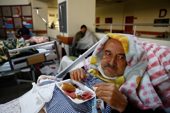 튀르키예 지진 이후 구조된 한 남성이 10일(현지시간) 튀르키예 카라만마라슈의 한 병원 침상에서 식사를 하고 있다. 로이터=연합뉴스