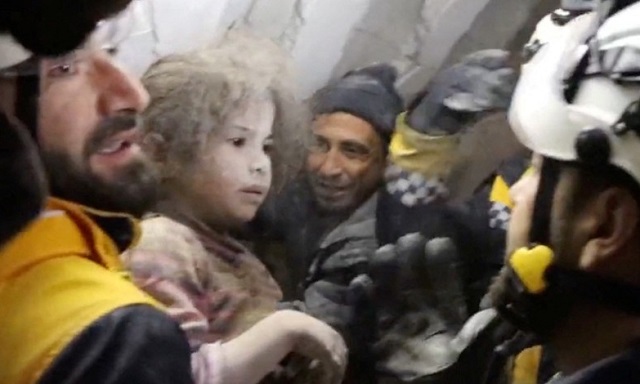 시리아 민간구조대인 '하얀 헬멧' 대원들이 8일(현지시간) 건물 잔해에서 여자아이를 구조한 뒤 안고 있다. 로이터연합뉴스
