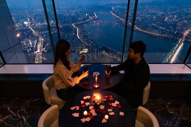 롯데월드태워 서울스카이의 스페셜 디너 코스 즐기는 커플의 모습./롯데물산 제공