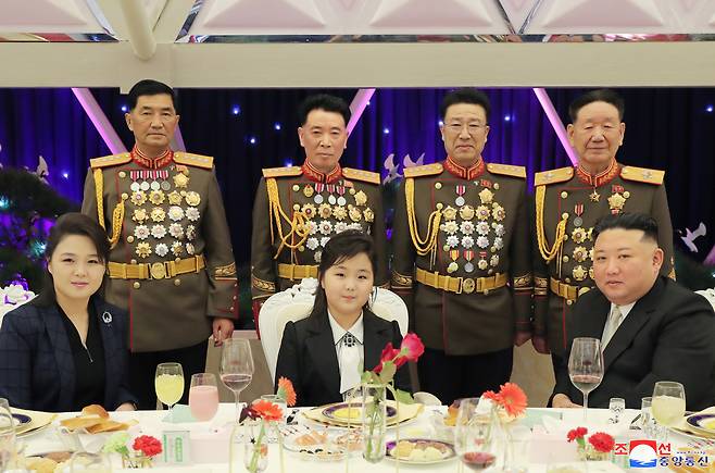 North Korean leader Kim Jong-un (front-R) posing for a photo with his daughter, known as Ju-ae (C), and his wife Ri Sol-ju (L) at a banquet the previous day to mark the 75th anniversary of the founding of the armed forces in this photo released by the state-run Korean Central News Agency on Wednesday. (Yonhap)