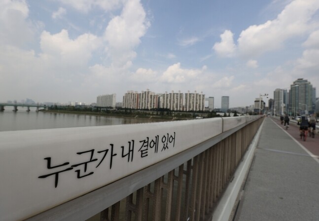 서울 한강대교 난간에 자살방지를 위한 문구, ‘누군가 내 곁에 있어'가 새겨져 있다. 연합뉴스