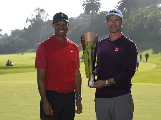 Adam Scott of Australia, right, poses with tournament host Tiger Woods and the trophy after winning the the Genesis Invitational at Riviera Country Club on Feb. 16, 2020 in Pacific Palisades, California. [GETTY IMAGES]