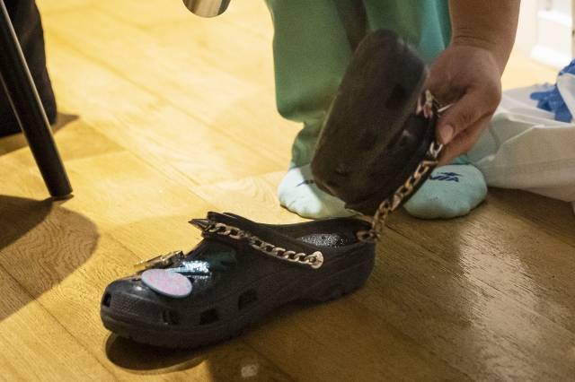 코로나19 대유행 초창기인 2020년 4월 28일(현지시간) 미국 일리노이주 시카고의 한 병원에서 간호사가 12시간 교대 근무를 마친 뒤 크록스 신발을 벗고 있다. AP뉴시스