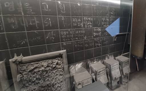 대구 중앙로역 지하 2층 기억공간 내부에 불에 녹아 버린 공중전화기와 희생자 가족이 적은 수많은 글씨가 새겨져 있다. 김덕용 기자