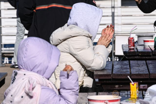 19일 서울 여의도 한강공원에서 한 시민이 두꺼운 옷을 입은 채 손을 비비고 있다.