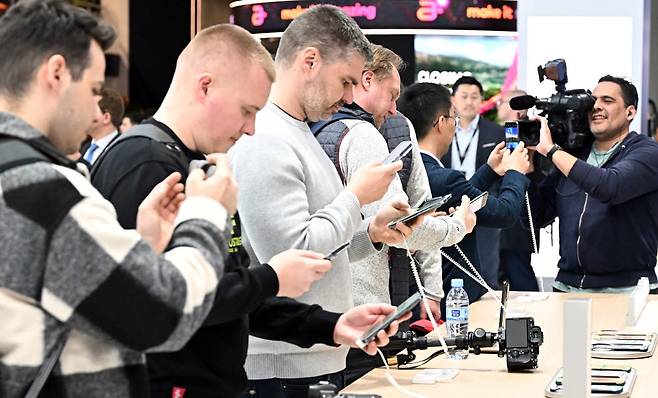 MWC23이 열린 스페인 바르셀로나 피라 그란 비아 전시장 아너 부스에서 참관객이 스마트폰을 살펴보고 있다. 바르셀로나(스페인)=이동근기자 foto@etnews.com