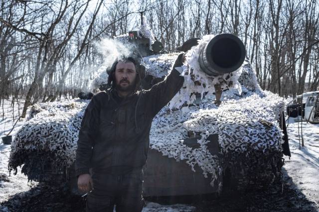 지난달 23일(현지시간) 우크라이나 동부 요충 바흐무트 주변 마을에 자리 잡은 T-64 전차 앞에서 우크라이나군 병사가 담배를 피우고 있다. AFP연합뉴스