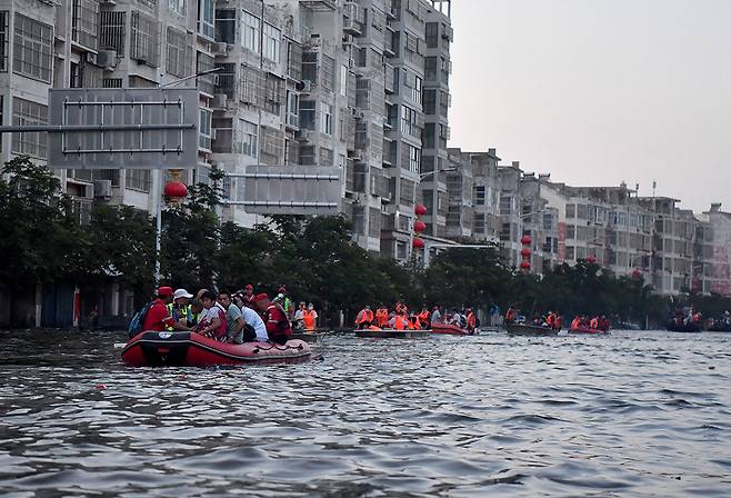 2021년 7월 중국 허난성 신샹시 웨이후이에서 홍수로 고립된 주민들이 구조용 고무보트를 타고 대피하고 있다. ⓒXinhua