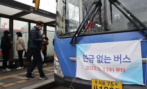 ‘현금 없는 버스’ 확대 운행 - 서울시가 1일부터 기존 18개 노선 436대였던 ‘현금 없는 버스’를 108개 노선 1876대로 늘려 운행하기 시작했다. 현금 없는 버스의 비중은 6%에서 25%로 대폭 늘었다. 서울역 앞 버스 정거장에 안내 현수막을 부착한 버스가 정차돼 있다. 연합뉴스