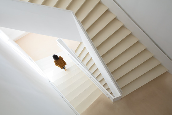 A visitor at Chang Ucchin Museum of Art walks down the museum's staircase. Its all-white interior is one factor that makes the museum unique. [GYEONGGI TOURISM ORGANIZATION]