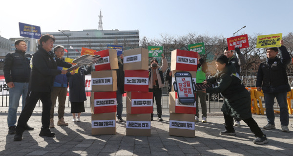 민주노총 공공운수노조 조합원들이 2일 서울 용산구 전쟁기념관 앞에서 올해 투쟁계획을 밝힌 뒤 ‘장시간 노동’, ‘실질임금 삭감’ 등이 적힌 상자를 무너뜨리는 퍼포먼스를 하고 있다. 연합뉴스