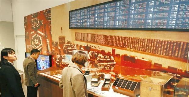 대한민국역사박물관에서 열리고 있는 특별전 ‘목돈의 꿈’을 찾은 관람객들이 한국 증권시장의 역사에 관한 자료를 살펴보고 있다.   연합뉴스