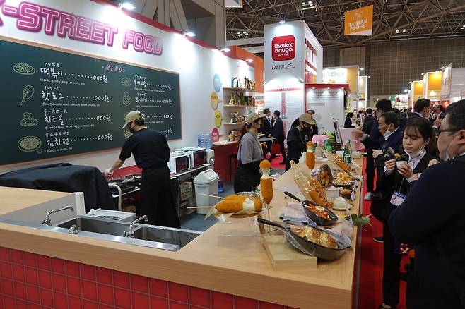 푸덱스 재팬에 설치된 한국 길거리음식 코너 (도쿄=연합뉴스) 박성진 특파원 = 7일 도쿄 빅사이트에서 개막한 식품 박람회인 '푸덱스 재팬'에서 일본인 바이어들이 한국 길거리 음식을 맛보고 있다. 2023.3.7
    sungjinpark@yna.co.kr