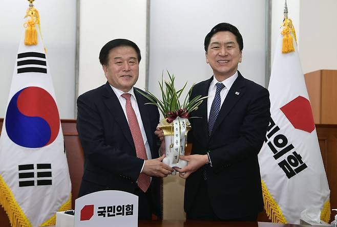 김기현(오른쪽) 국민의힘 대표가 9일 서울 여의도 국회에서 이진복(왼쪽) 대통령실 정무수석을 만나 윤석열 대통령의 축하 난을 받고 있다. /뉴스1