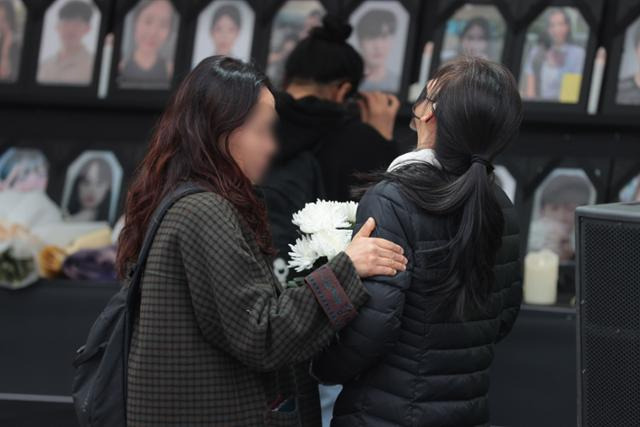 지난달 18일 오전 서울 중구 서울광장에 설치된 10·29 이태원 참사 분향소에서 한 시민이 눈물 흘리는 유족을 위로하고 있다. 연합뉴스