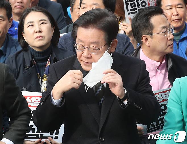 이재명 더불어민주당 대표가 11일 서울 중구 서울시청광장에서 열린 '강제동원 굴욕해법 강행 규탄 및 일본의 사죄배상 촉구 2차 범국민대회'에서 마스크를 벗고 있다. 2023.3.11/뉴스1 ⓒ News1 송원영 기자