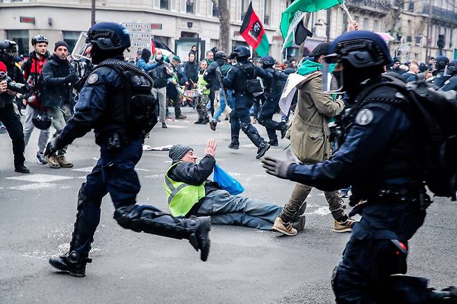 프랑스 전역에서 정부의 연금개혁 법안에 반대하는 시위가 열린 11일(현지시간) 수도 파리에서 시위대와 진압 경찰 간 충돌이 있는 가운데 한 시위자가 도로에 넘어져 있다. 이날 프랑스 상원에서는 반대 시위 속에서도 연금개혁 법안을 통과시켰다. 【EPA연합뉴스】