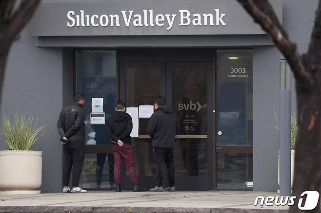 SVB 본점. 행인들이 폐쇄 공고를 읾고 있다. ⓒ AFP=뉴스1