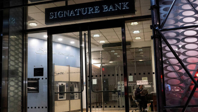 한산한 시그니처은행 미국 뉴욕시에 있는 시그니처은행 한 지점의 보안요원이 이 은행이 파산한 12일 밤(현지시간) 지점 안에서 신문을 읽고 있다. 로이터연합뉴스
