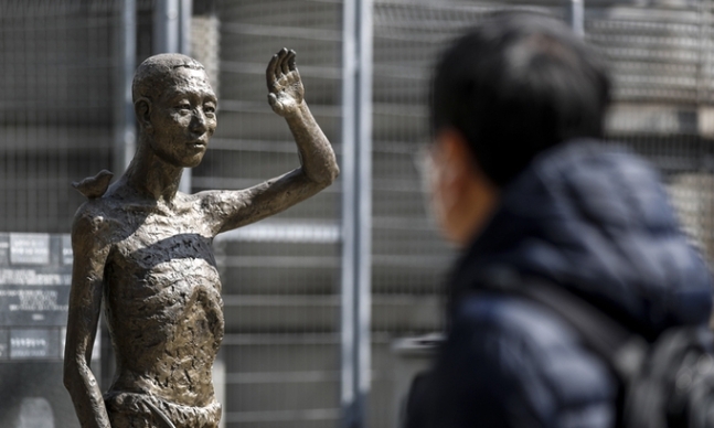 지난 6일 서울 용산구 용산역광장에 세워진 강제징용노동자상 앞에서 한 시민이 동상을 바라보고 있다. 뉴시스