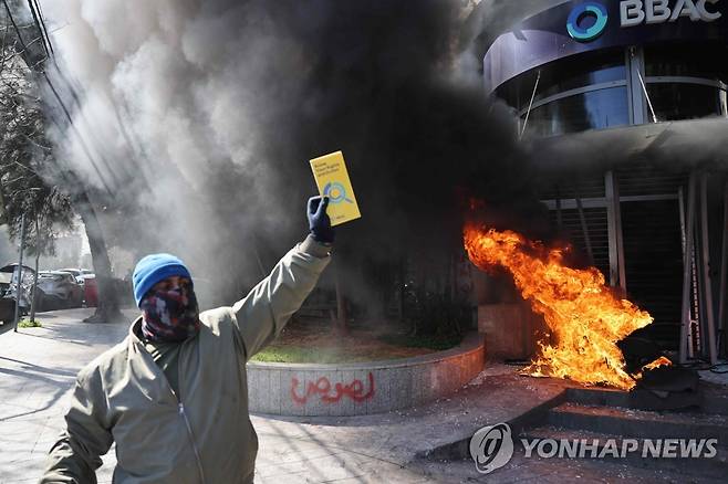 예금 인출 제한에 항의하며 은행 지점 앞에 불을 지른 레바논 시위 참가자. [AFP 연합뉴스 자료사진. 재판매 및 DB 금지]
