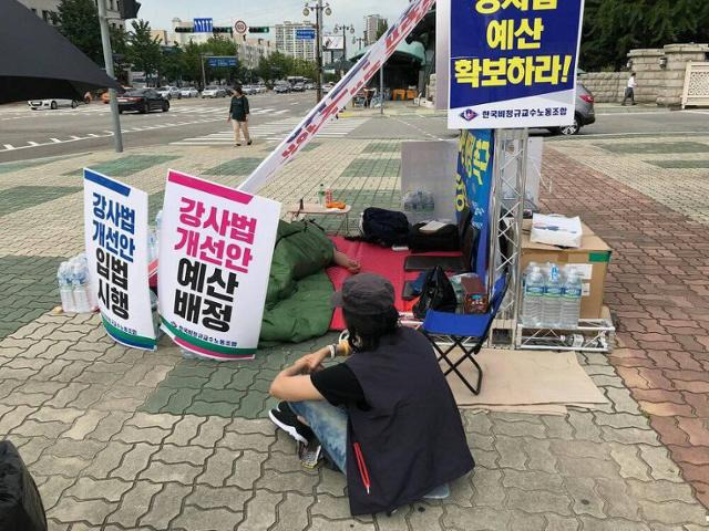 2018년 국회 앞에서 있었던 강사법 농성 현장에서 앉아 있는 정보라 작가. 정보라 작가 제공