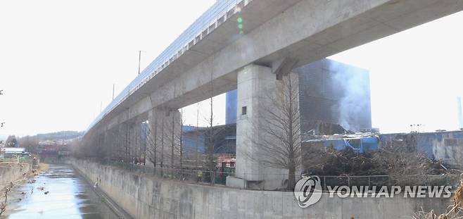 하천 끼고 있는 한국타이어 대전공장 (대전=연합뉴스) 강수환 기자 = 한국타이어 대전공장 화재 발생 사흘째인 14일 오후 잔불 정리 작업이 한창인 공장에서 연기가 새어 나오고 있다. 2023.3.14 swan@yna.co.kr