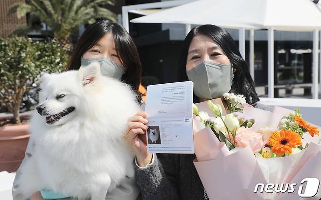 16일 오전 제주국제공항 국내선 청사에서 국내 최초로 운항한 반려견 동반 전세기 탑승객들이 반려견과 반려견 전용 여권을 들고 기념 촬영하고 있다. 한국관광공사와 반려동물 여행플랫폼 ‘반려생활’, 소형항공사 ‘하이에어’가 출시한 반려동물 동반 전세기 상품은 김포와 제주를 왕복하는 2박3일 일정으로, 연말까지 월 1회씩 총 10회 운영한다. 2023.3.16/뉴스1 ⓒ News1 고동명 기자