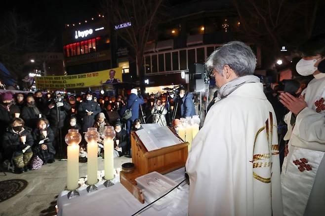 지난해 12월 25일 오후 서울 용산구 녹사평역 광장에 마련된 이태원참사 희생자 시민분향소에서 천주교 정의구현전국사제단 소속 신부들이 참사 희생자와 유가족을 위한 성탄대축일 미사를 집전하고 있다. [이미지출처=연합뉴스]