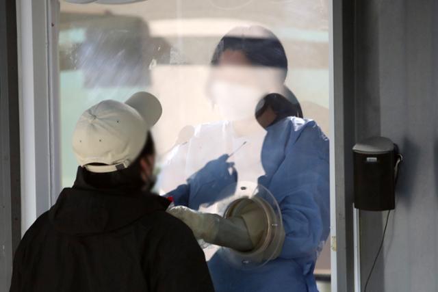 13일 오전 서울 용산구보건소 코로나19 선별진료소에서 한 시민이 검사를 받고 있다. 뉴스1
