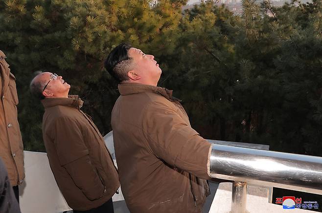 김정은 북한 국무위원장이 노동당 및 미사일 총국 인사들과 발사된 미사일을 지켜보는 모습. [조선중앙통신/연합뉴스]