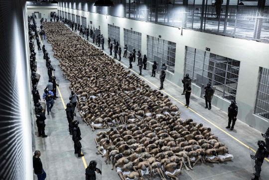 15일 엘살바도르 테코루카에 있는 테러범 수용센터에서 이송된 죄수들이 바닥에 앉아 있다. AFP 연합뉴스
