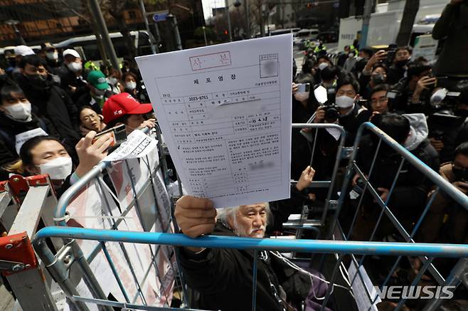 [서울=뉴시스] 조성우 기자 = 박경석 전국장애인차별철폐연대(전장연) 공동상임대표가 17일 오전 서울 종로구 서울경찰청 민원실 앞에서 경찰이 제시한 체포영장을 보여주고 있다. 2023.03.17. xconfind@newsis.com