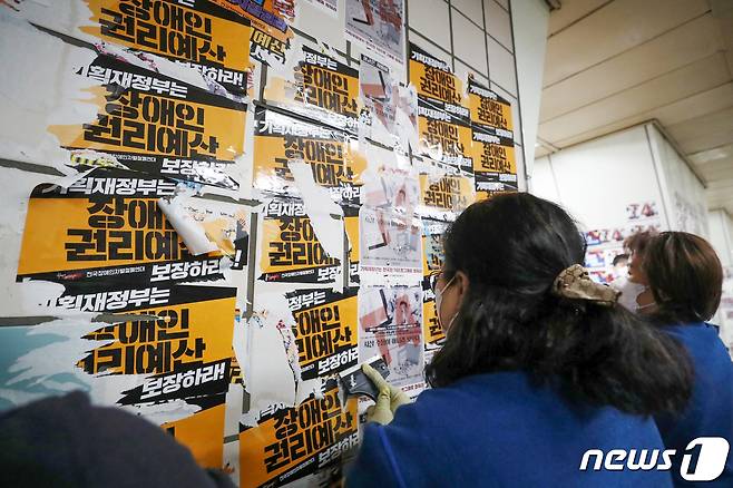 서울교통공사의 자회사 서울메트로환경 미화원들이 27일 오전 용산구 4호선 삼각지역 승강장에서 전국장애인차별철폐연대(전장연)의 출근길 시위 당시 부착한 선전용 스티커를 제거하고 있다. 2023.2.27/뉴스1 ⓒ News1 민경석 기자