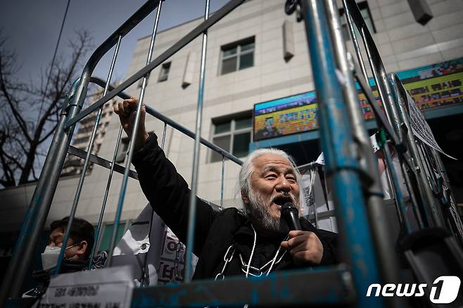 박경석 전국장애인차별철폐연대(전장연) 대표가 17일 오전 서울 종로구 서울지방경찰청 앞에서 몸에 쇠사슬을 두르고 철창 속에서 법원의 체포영장 발부에 따른 입장발표 기자회견을 하고 있다.  2023.3.17/뉴스1 ⓒ News1 이승배 기자