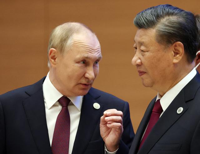 지난해 9월 우즈베키스탄 사마르칸트에서 열린 상하이협력기구(SCO) 정상회의에서 블라디미르 푸틴(왼쪽) 러시아 대통령과 시진핑 중국 국가주석이 대화하고 있다. 사마르칸트=타스 연합뉴스