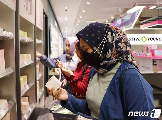 외국인 관광객들이 명동 올리브영 매장을 찾아 '조선미녀' 브랜드 상품을 살펴보고 있다.(CJ올리브영 제공)