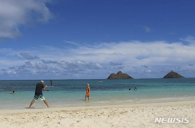 [카일루아=AP/뉴시스] 하와이 카일루아에 있는 라니카이 해변에서 즐기고 있는 관광객들 2023.03.19. photo@newsis.com