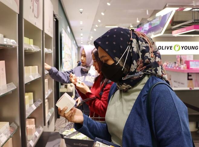 외국인 관광객들이 명동 올리브영 매장을 찾아 ‘조선미녀’ 브랜드 상품을 살펴보고 있다.  | CJ올리브영 제공
