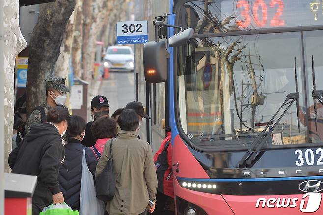 대중교통 마스크 착용 의무 해제 첫 날인 20일 오전 경북 포항시 죽도시장 시내버스 정류장에서 시민들이 마스크를 착용한 채 탑승하고 있다.2023.3.20/뉴스1 ⓒ News1 최창호 기자